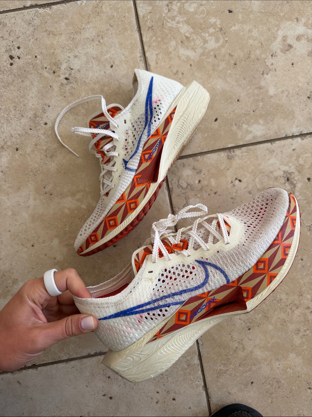 Nike Women's White Running Sneakers with Orange Geometric Trim and Blue Swoosh